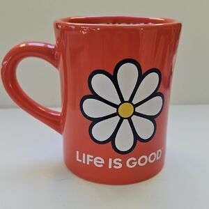 LIFE IS GOOD SALMON COLORED COFFEE CUP WITH A DAISY ON IT